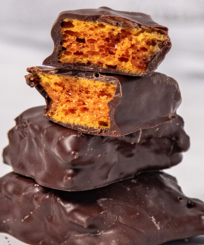 Stack of dark chocolate honeycomb candies with the honeycomb texture visible on the inside