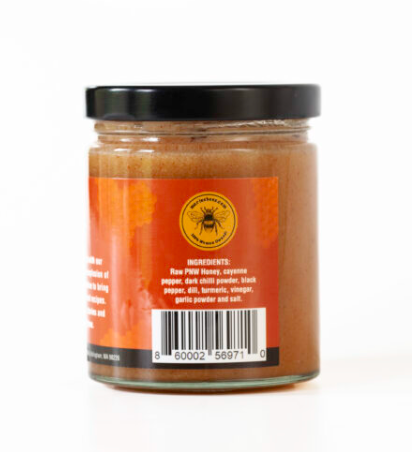 Jar of Hot Creamed Honey with a barcode, ingredients and the 100% Woman Owned Logo. 